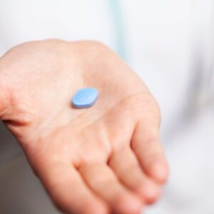 A viagra pill in a hand to represent outside tools for sex therapy.